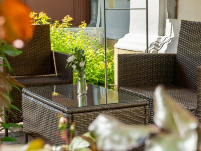 Restauracja U Pana Cogito, stolik w ogródku z wazonikiem kwiatów